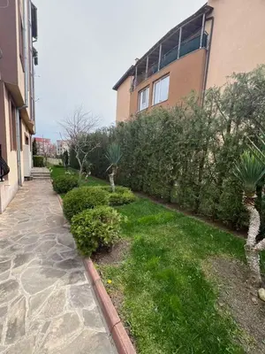 a garden with plants and trees next to a building at Apartment Chocolate Ravda in Ravda