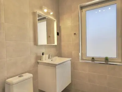 a bathroom with a toilet and a sink and a window at Carina Beach - Private apartment - BSR - 1 in Sunny Beach