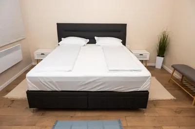 a large bed in a bedroom with two night stands at Apartment Maria in Burgas City