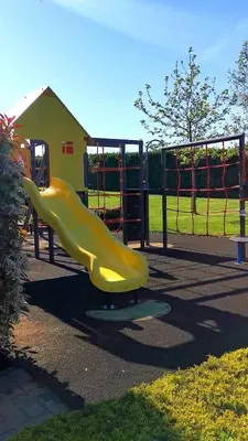 a yellow slide at a playground in a park at Студио Черноморски залив Атия Резорт in Chernomorets