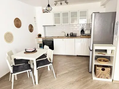 a kitchen with a table and chairs and a refrigerator at Urban Oasis in Varna City