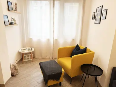a living room with a yellow chair and a table at Urban Oasis in Varna City
