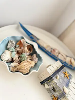 a bowl of seashells on a plate next to a toy boat at Urban Oasis in Varna City