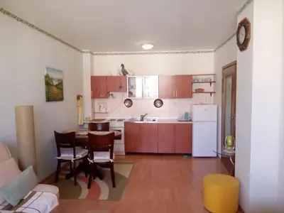 a kitchen with a table and chairs and a refrigerator at Splendid sunny seasons in Byala