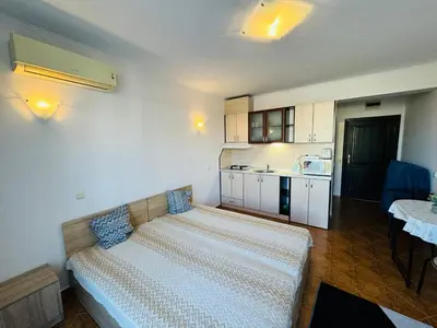 a bedroom with a bed and a kitchen with a table at SAINT ELENA APART COMPLEX 47 Studio in Sunny Beach