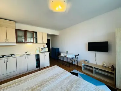 a room with a bed and a kitchen with a tv at SAINT ELENA APART COMPLEX 47 Studio in Sunny Beach