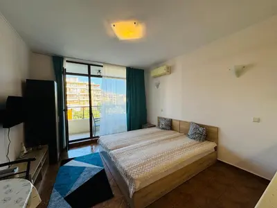 a bedroom with a bed and a flat screen tv at SAINT ELENA APART COMPLEX 47 Studio in Sunny Beach