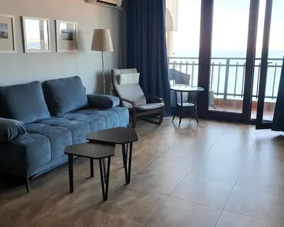 a living room with a couch and chairs and a balcony at Panorama Sea View in Sveti Vlas