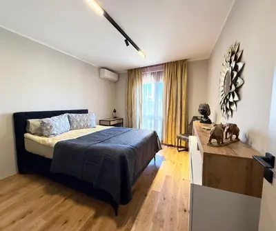 a bedroom with a bed and a desk and a window at Sea Garden luxury appartments in Varna City