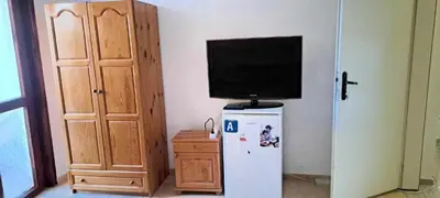 a television on top of a refrigerator in a room at Family House Victoria' Garden in Primorsko