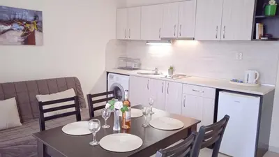 a kitchen with a table and chairs and a kitchen with a table and a counter at Апартамент в непосредствена близост до плажа III in Burgas City
