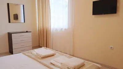 a bedroom with a bed with a dresser and a mirror at Апартамент в непосредствена близост до плажа III in Burgas City