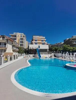 a swimming pool with blue water and some buildings at Grand Villa Perle in Sveti Vlas