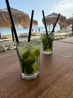 two cocktails sitting on a table near the beach at Grand Villa Perle in Sveti Vlas