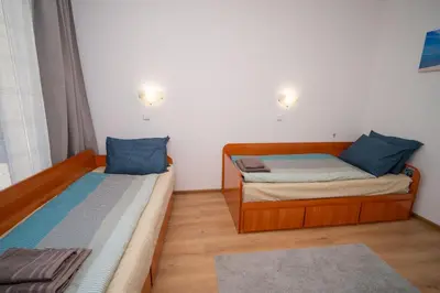 two beds in a small room with blue pillows at Spacious 2BD Apartment - Walk to City Center and free Parking by Flat Mаnager in Burgas City