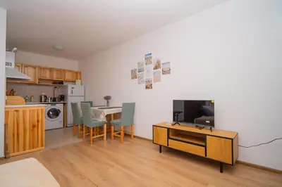 a kitchen and dining room with a table and chairs at Spacious 2BD Apartment - Walk to City Center and free Parking by Flat Mаnager in Burgas City
