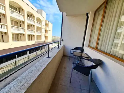 a balcony of a building with a table and chairs at Stamopolu Apartments in Primorsko