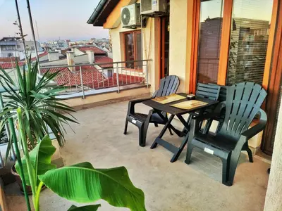 a patio with a table and chairs on a balcony at Апартамент Цар Самуил in Burgas City