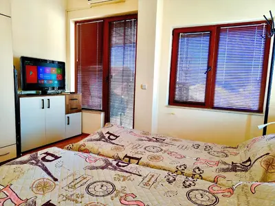 a bedroom with a bed and a flat screen tv at Апартамент Цар Самуил in Burgas City