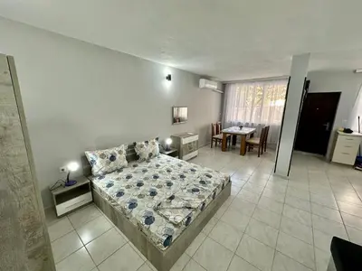 a bedroom with a bed and a table and chairs at Студио Боряна in Pomorie