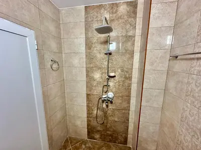 a shower with a shower head in a bathroom at Студио Боряна in Pomorie