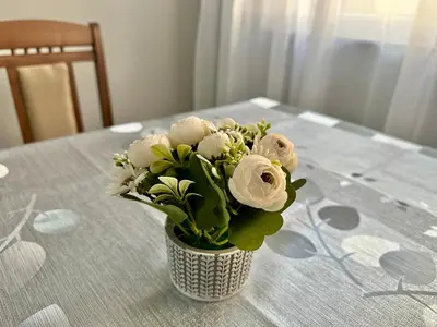 a vase filled with white flowers on a table at Студио Боряна in Pomorie