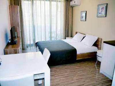 a hotel room with a bed and a television at APART-HOTEL Stamopolu Lux с изглед към морето in Primorsko