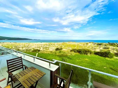 a balcony with a table and chairs and the ocean at APART-HOTEL Stamopolu Lux с изглед към морето in Primorsko