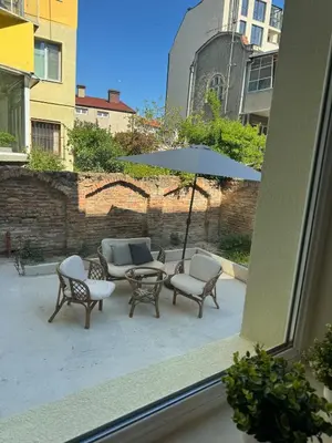 a patio with chairs and a table and an umbrella at Heart of Varna, Close to the Sea in Varna City