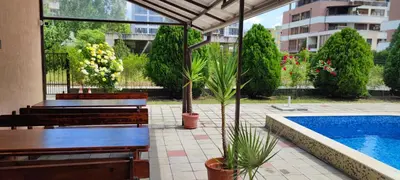a patio with benches and a swimming pool at Hotel 415 in Sunny Beach