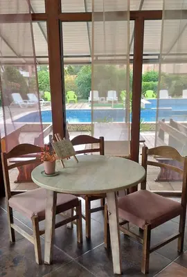 a table and chairs in a room with a pool at Hotel 415 in Sunny Beach