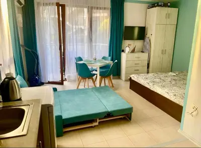 a bedroom with a bed and a table and a room at Studio Blue Triumph in Sveti Vlas