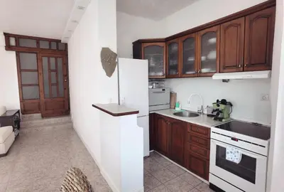 a kitchen with wooden cabinets and a white refrigerator at Вила Алба in Lozenets