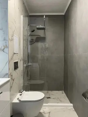 a bathroom with a shower and a toilet and a sink at Lago Mare Apartment in Pomorie