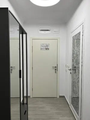 a hallway with a white door with a sign on it at Lago Mare Apartment in Pomorie