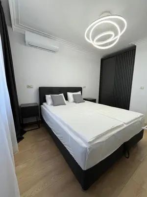 a bedroom with a large white bed with a chandelier at Lago Mare Apartment in Pomorie
