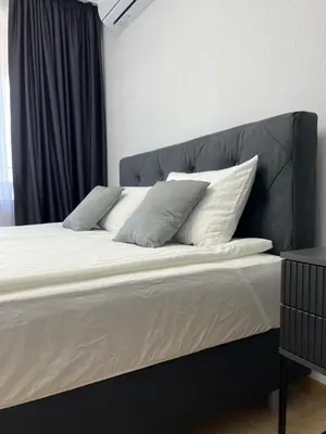 a large bed with white sheets and pillows on it at Lago Mare Apartment in Pomorie