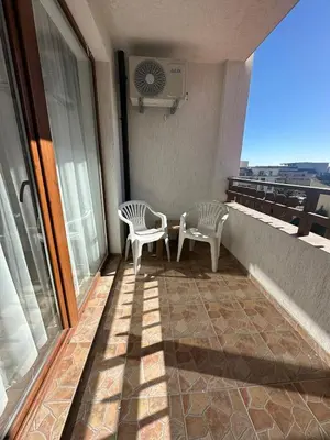 two white chairs sitting on a balcony with a view at Apartment in the complex Olymp in Sveti Vlas