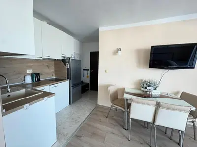 a kitchen and dining room with a table and chairs at Pomorian Pearl in Pomorie
