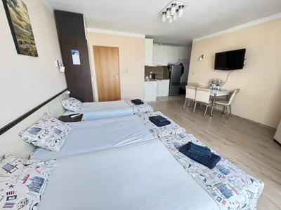 a hotel room with two beds and a kitchen at Pomorian Pearl in Pomorie