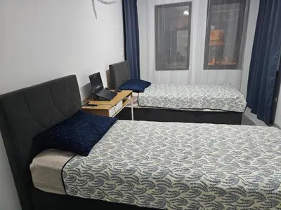 a room with two beds and a desk with a laptop at 3 комнатные новые апартаменты у моря in Sveti Vlas