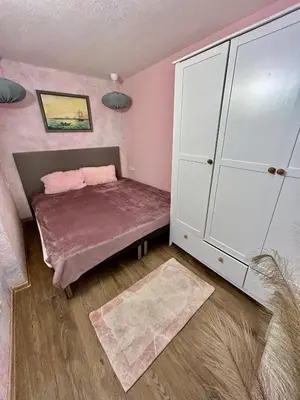 a small bedroom with a bed and a white cabinet at Family in Varna City