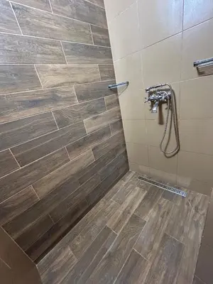 a bathroom with a shower with a wooden floor at Family in Varna City