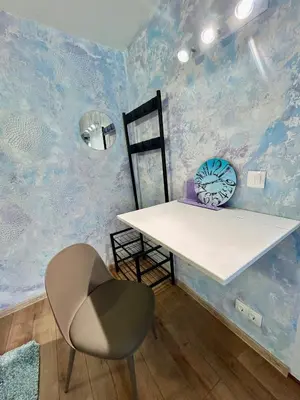 a table and a chair in a room with blue walls at Family in Varna City