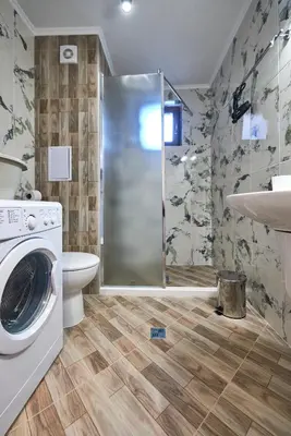 a bathroom with a shower and a washing machine at АПАРТАМЕНТИ Радина in Pomorie