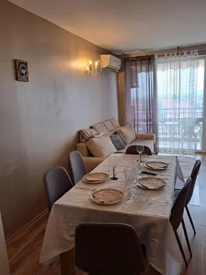 a dining room table with chairs and a couch at Apartament in Aheloy in Aheloy