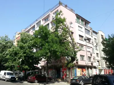 a tall white building with cars parked in front of it at Studio Zora in Burgas City