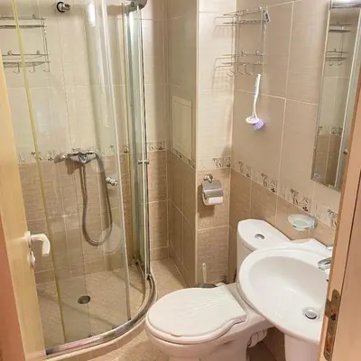 a bathroom with a shower and a toilet and a sink at Тристаен апартамент в затворен комплекс in Chernomorets