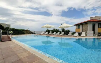 a large swimming pool with chairs and umbrellas at Appart complex - Egrek in Lozenets