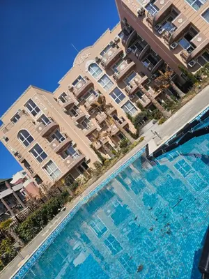 an overhead view of a swimming pool in front of buildings at Релакс в Равда! in Ravda